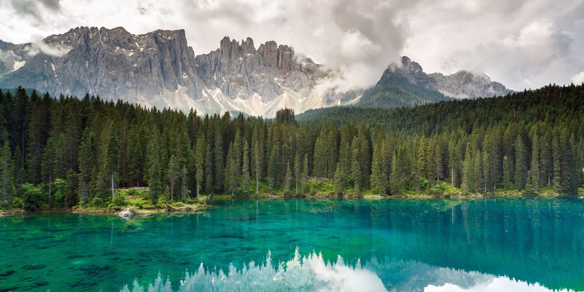 A forest lake below mountains